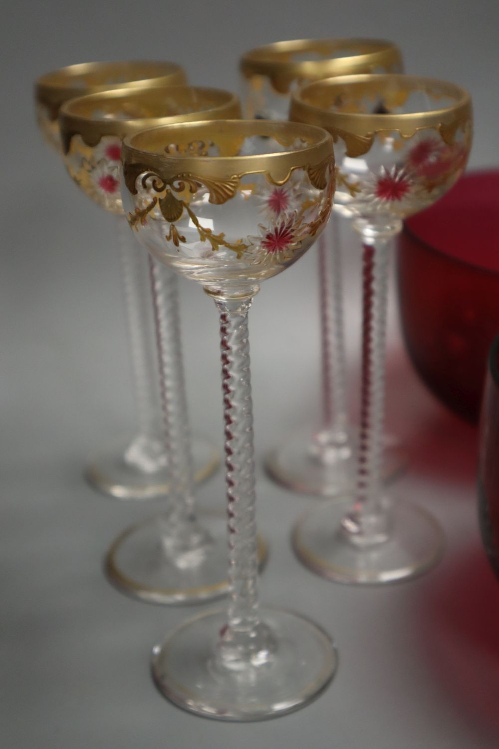 A pair of cranberry rinsers, four airtwist gilt decorated glasses, a Greek key patterned wine glass, an etched glass with motto and a v